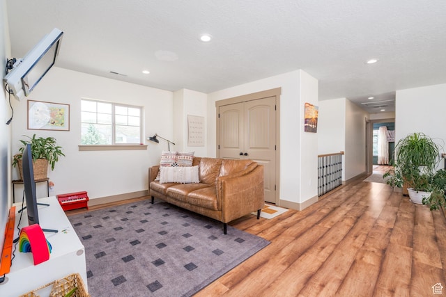 living room featuring wood-type flooring and a textured ceiling