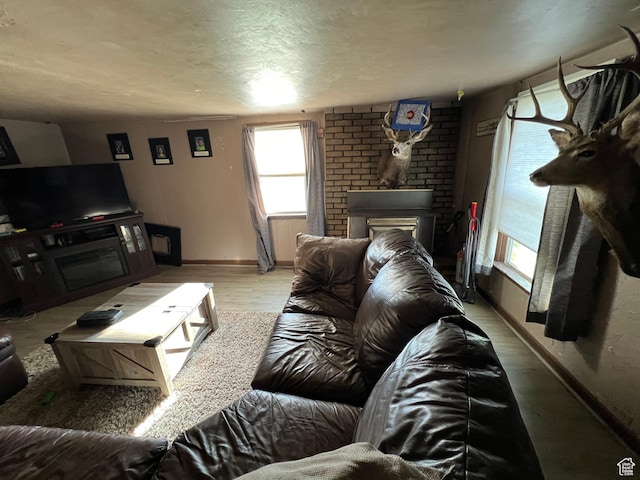 736 E Hatchery Rd, Bicknell, UT 84715 - living room featuring baseboards, wood finished floors, a textured ceiling, and a fireplace