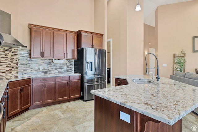 1536 S Cliff Dr, Apple Valley, UT 84737 - kitchen with a towering ceiling, wall chimney range hood, backsplash, stainless steel fridge, and hanging light fixtures