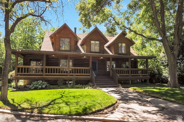 log home featuring covered porch, roof with shingles, and a front lawn
