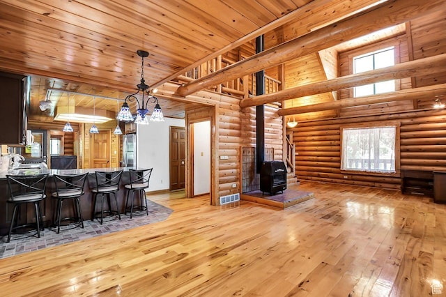 11996 S 3600 W, Riverton, UT 84065 - interior space with a wood stove, light wood finished floors, wood ceiling, and a breakfast bar