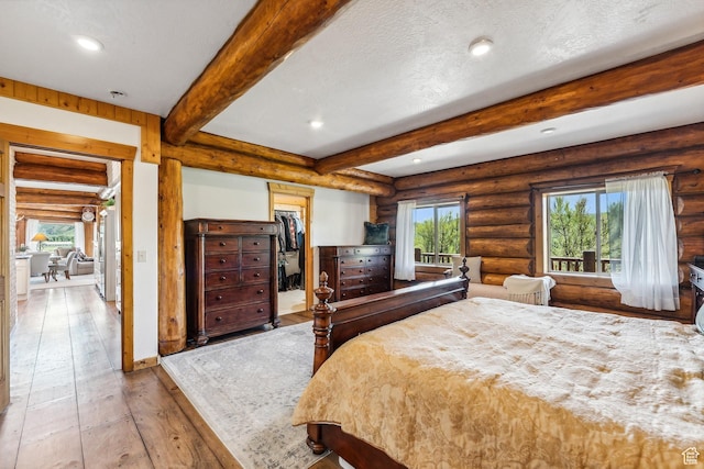 6690 N State Road 32, Peoa, UT 84061 - bedroom with beam ceiling, hardwood / wood-style flooring, multiple windows, and log walls