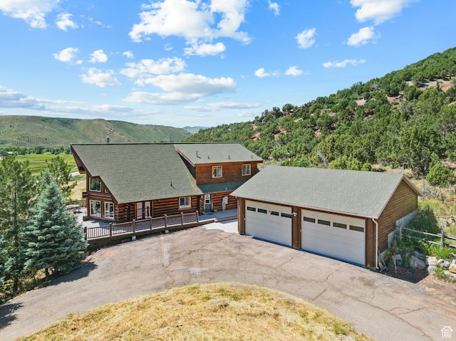 6690 N State Road 32, Peoa, UT 84061 - view of front of home featuring a detached garage, log exterior, an outbuilding, and a deck with mountain view