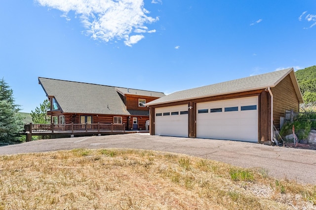 6690 N State Road 32, Peoa, UT 84061 - view of front facade featuring a garage, a deck, an outdoor structure, and aphalt driveway