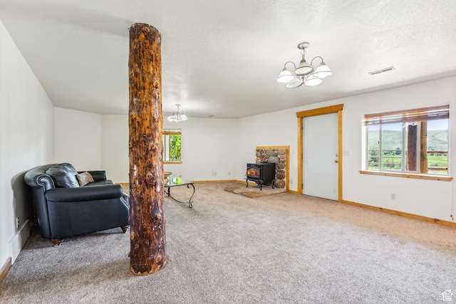 6690 N State Road 32, Peoa, UT 84061 - living area featuring a wood stove, visible vents, carpet floors, and a chandelier