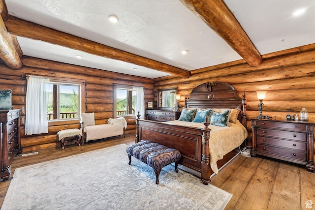 6690 N State Road 32, Peoa, UT 84061 - bedroom with beam ceiling, light wood-style flooring, a textured ceiling, recessed lighting, and log walls