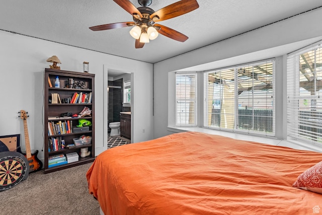 carpeted bedroom featuring connected bathroom, a textured ceiling, and ceiling fan