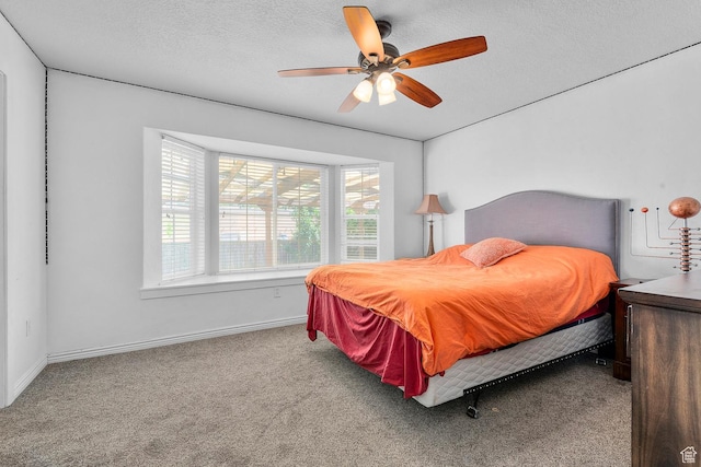 carpeted bedroom featuring ceiling fan, baseboards, and a textured ceiling