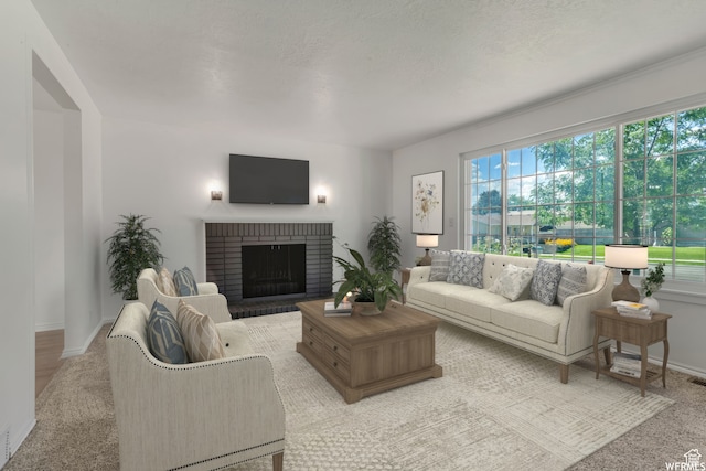 living room with a brick fireplace and light wood-type flooring