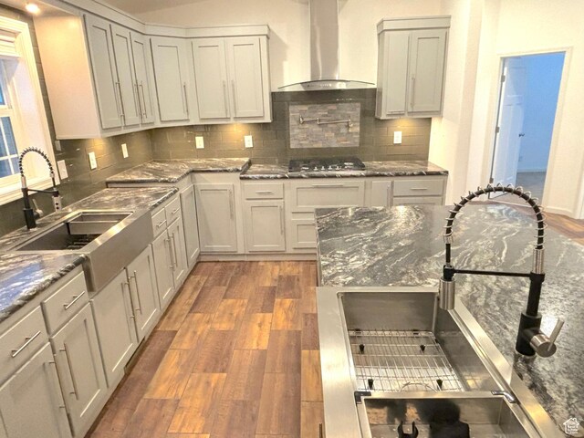 944 E Kiva Dr, Blanding, UT 84511 - kitchen featuring wall chimney exhaust hood, wood finished floors, tasteful backsplash, and a sink