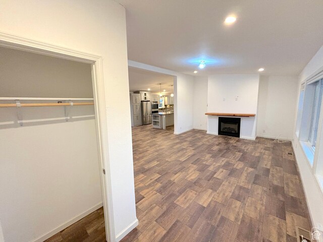 944 E Kiva Dr, Blanding, UT 84511 - below grade area with freestanding refrigerator, recessed lighting, a fireplace, dark wood finished floors, and baseboards