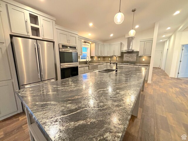 944 E Kiva Dr, Blanding, UT 84511 - kitchen with a sink, wall chimney range hood, a large island, and appliances with stainless steel finishes
