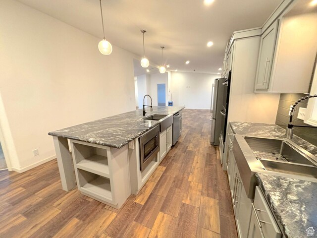 944 E Kiva Dr, Blanding, UT 84511 - kitchen with dark wood-style flooring, a sink, open shelves, stainless steel appliances, and a kitchen island with sink