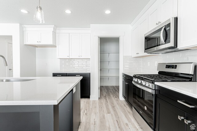 3772 W 1200 N Unit 135, Lehi, UT 84043 - kitchen with appliances with stainless steel finishes, white cabinets, light wood-style flooring, light countertops, and recessed lighting
