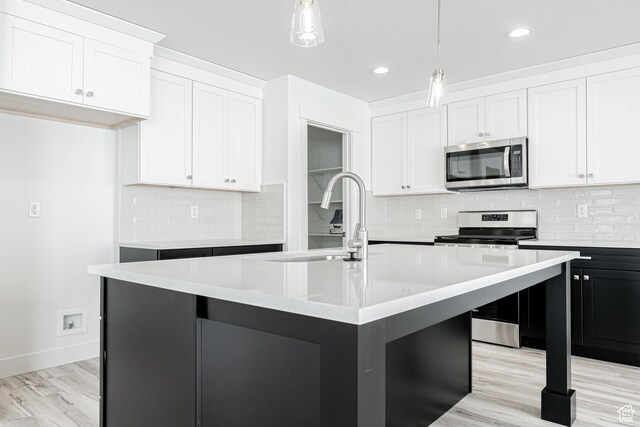3772 W 1200 N Unit 135, Lehi, UT 84043 - kitchen featuring appliances with stainless steel finishes, a sink, light countertops, decorative light fixtures, and white cabinetry