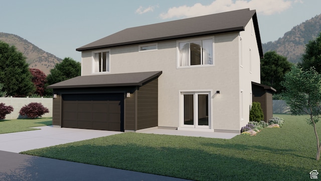 view of front of home featuring a garage, a front lawn, and a mountain view
