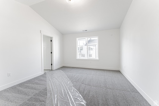 spare room with lofted ceiling and carpet flooring