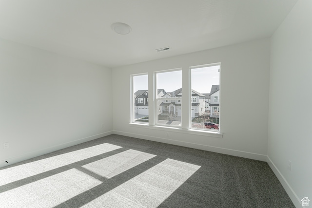 unfurnished room with dark colored carpet