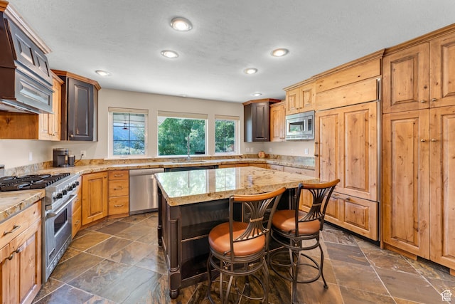 9065 Meadow Dr, Sundance, UT 84604 - kitchen featuring a sink, appliances with stainless steel finishes, a breakfast bar, and stone tile floors