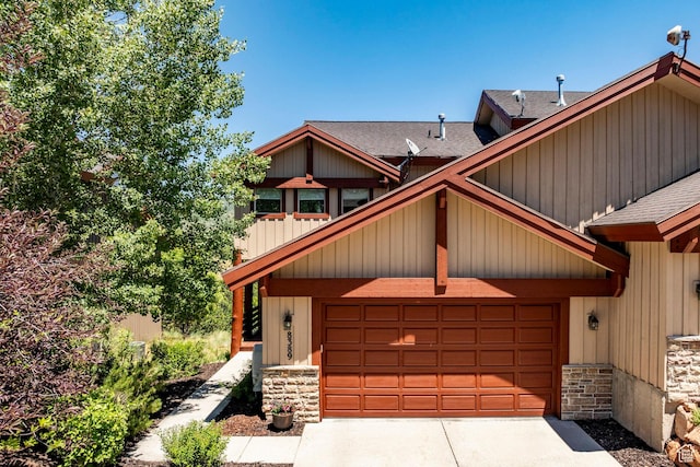8389 N Pointe Dr, Park City, UT 84098 - view of front of property featuring stone siding, driveway, roof with shingles, and an attached garage