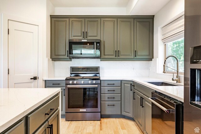 8389 N Pointe Dr, Park City, UT 84098 - kitchen featuring gray cabinets, stainless steel appliances, a sink, light wood-style floors, and light stone counters