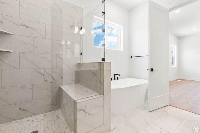 bathroom with baseboards, a soaking tub, recessed lighting, marble finish floor, and a tile shower