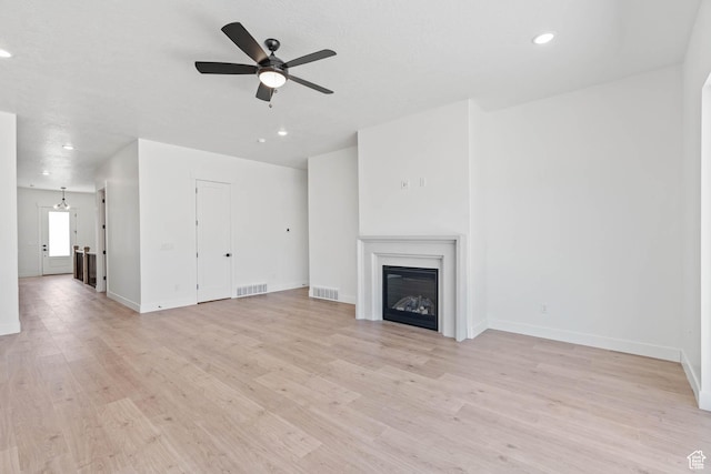 unfurnished living room with visible vents, baseboards, and ceiling fan