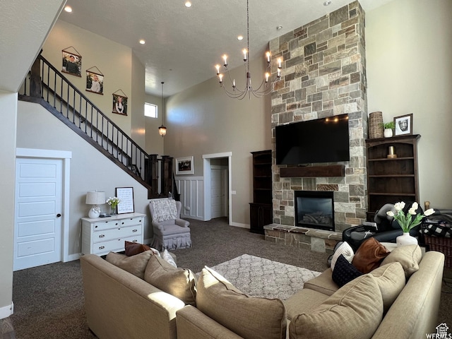 living room with stairs, a towering ceiling, a fireplace, carpet floors, and baseboards