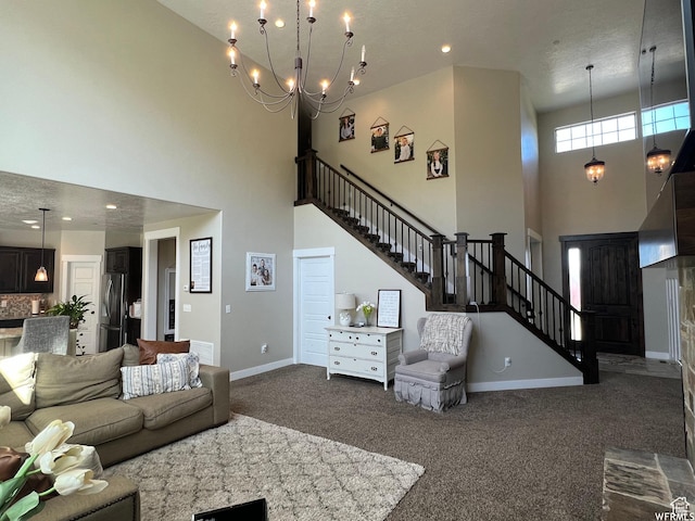 living room with stairs, dark colored carpet, and a high ceiling