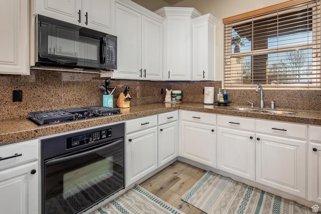 kitchen with white cabinetry, sink, tasteful backsplash, and black appliances