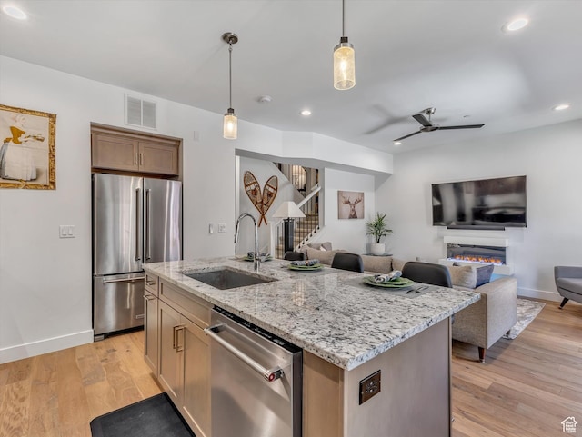 8257 N Sandalwood Ln, Park City, UT 84098 - kitchen featuring ceiling fan, sink, stainless steel appliances, pendant lighting, and a kitchen island with sink
