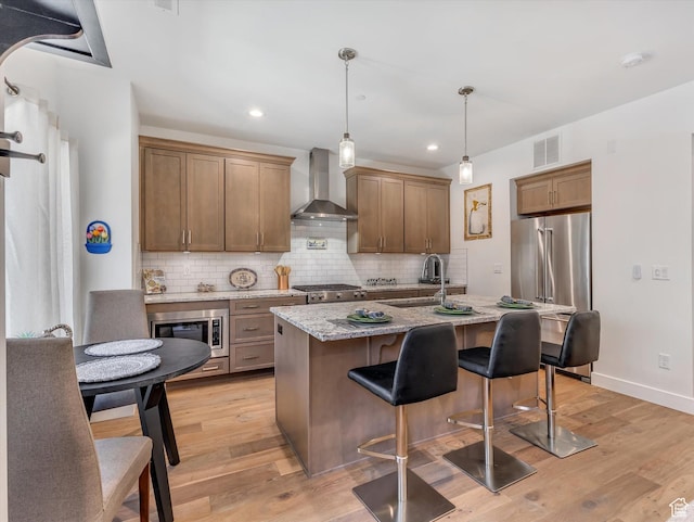 8257 N Sandalwood Ln, Park City, UT 84098 - kitchen featuring light stone countertops, sink, wall chimney range hood, a kitchen island with sink, and appliances with stainless steel finishes