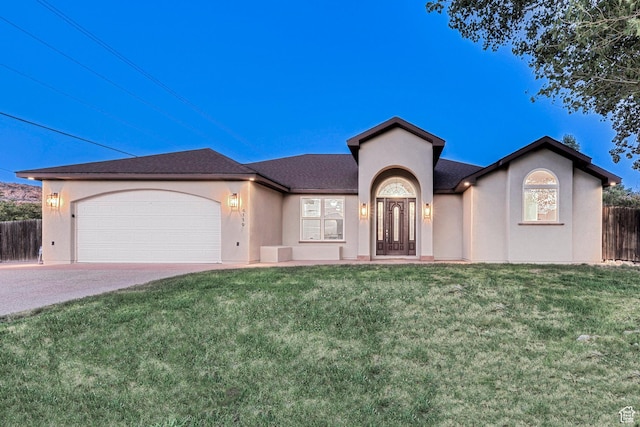ranch-style house featuring a front yard, fence, a garage, and stucco siding