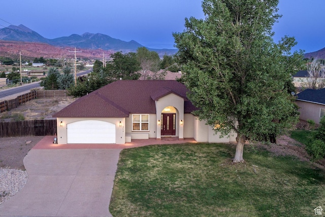 4119 Valle Del Sol Dr, Moab, UT 84532 - view of front of property with driveway, stucco siding, a mountain view, and an attached garage