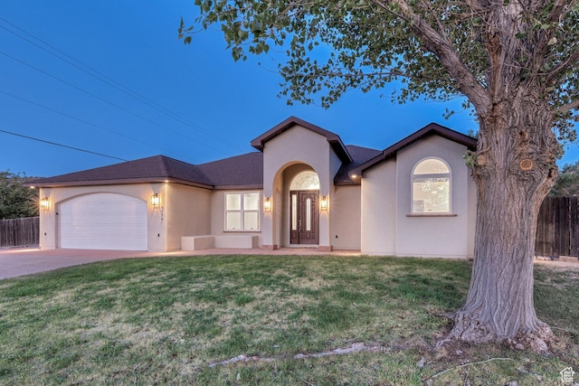 4119 Valle Del Sol Dr, Moab, UT 84532 - view of front of house with stucco siding, driveway, a front yard, a garage, and fence