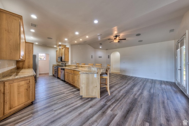 4119 Valle Del Sol Dr, Moab, UT 84532 - kitchen featuring visible vents, arched walkways, a sink, a peninsula, and a breakfast bar area