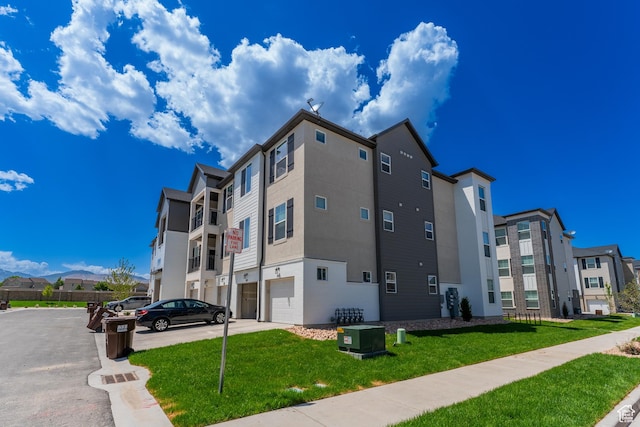 4714 W Dearing Ln Unit Kk304, Riverton, UT 84096 - view of building exterior featuring a garage, driveway, and a residential view