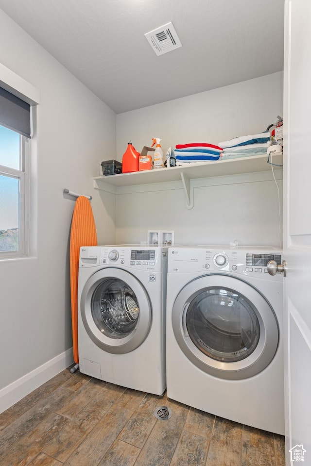 laundry area with laundry area, wood finished floors, visible vents, baseboards, and washing machine and clothes dryer
