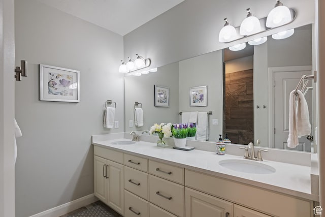 bathroom with double vanity, a sink, and baseboards