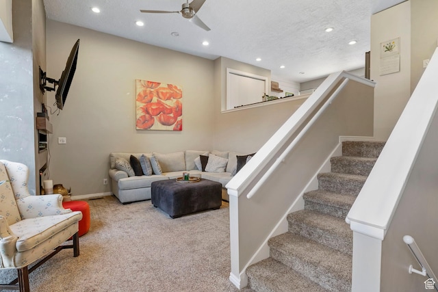 carpeted living room with a textured ceiling and ceiling fan