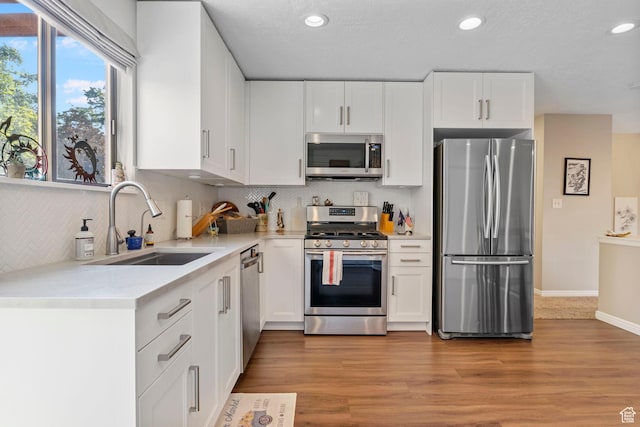 kitchen featuring light hardwood / wood-style floors, white cabinetry, sink, and appliances with stainless steel finishes