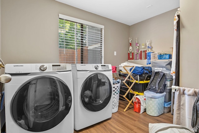 laundry room with washer and clothes dryer and light hardwood / wood-style flooring