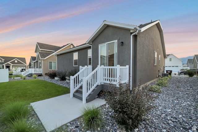 6618 N Furner Rdg, Eagle Mountain, UT 84005 - property exterior at dusk featuring a garage and a lawn