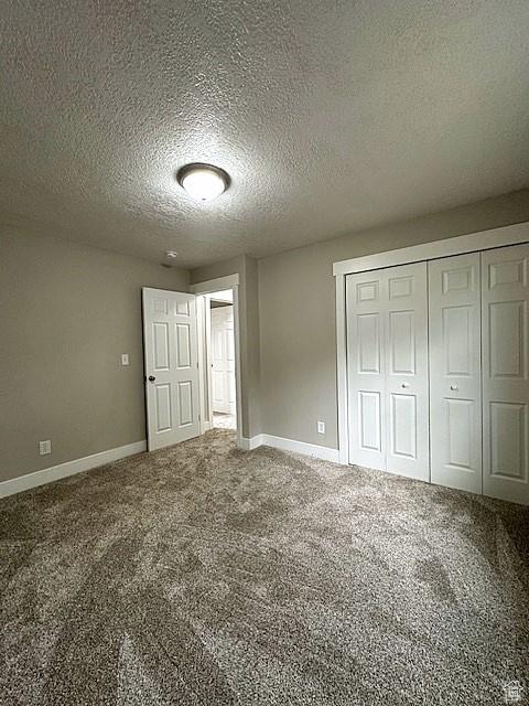 3715 W 11500 N, Neola, UT 84053 - unfurnished bedroom featuring a closet, a textured ceiling, and carpet floors