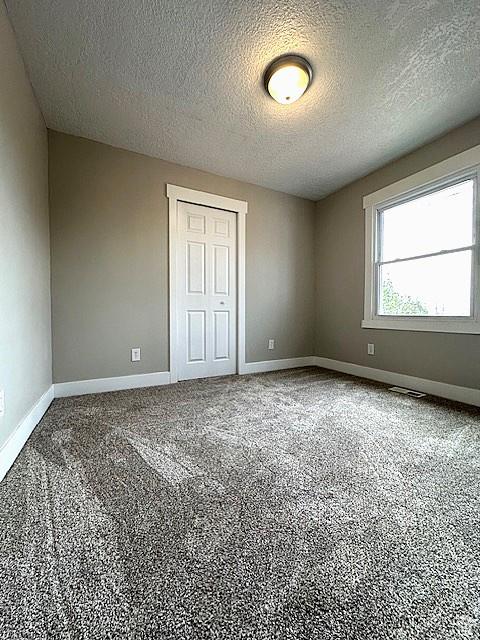 3715 W 11500 N, Neola, UT 84053 - unfurnished bedroom featuring a textured ceiling and a closet