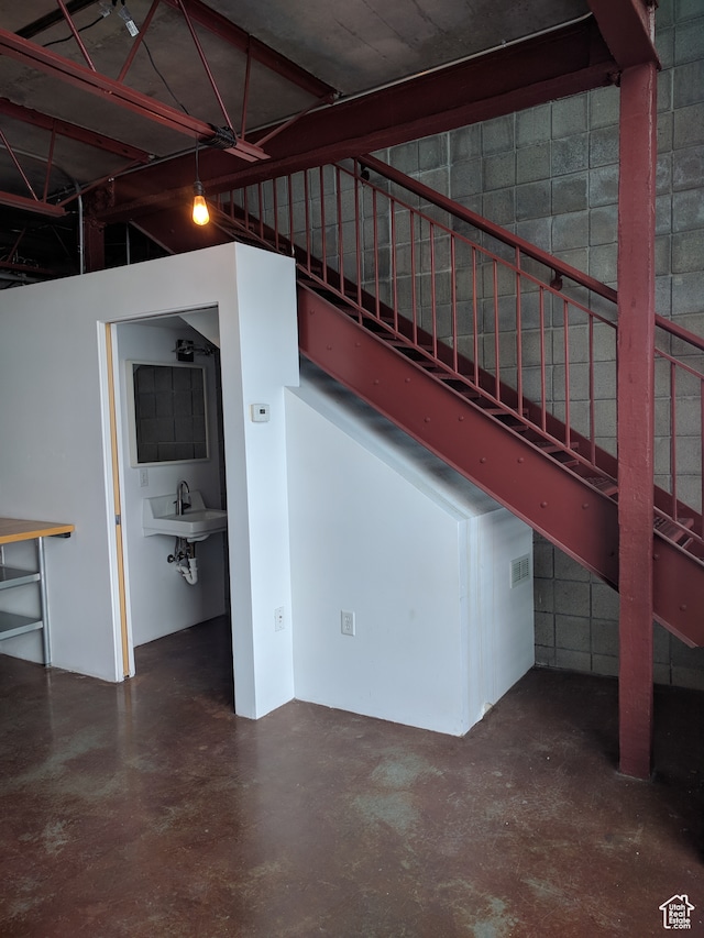 staircase featuring concrete flooring and sink