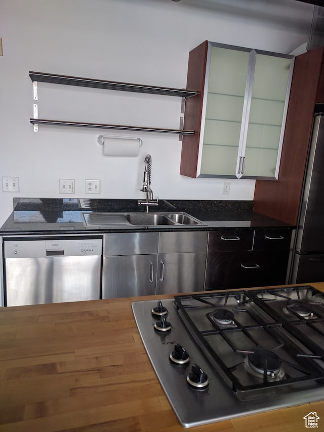kitchen with hardwood / wood-style floors, appliances with stainless steel finishes, and sink