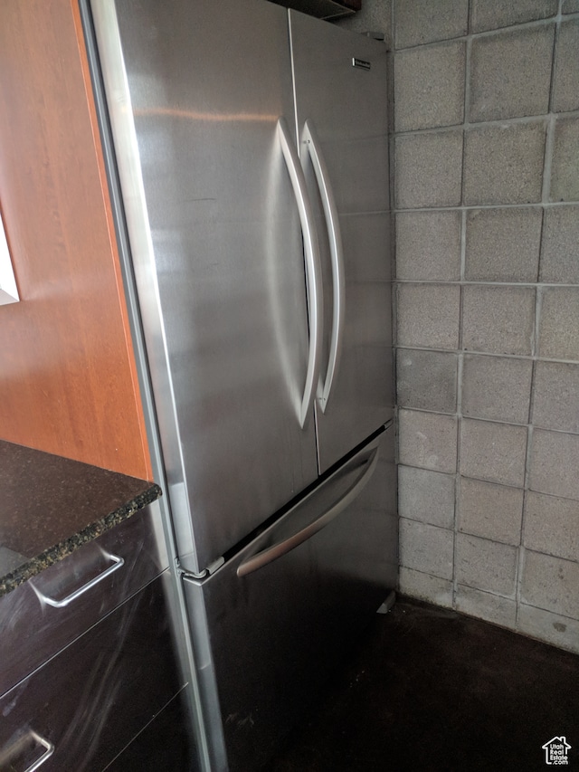 interior details with stainless steel refrigerator and a drop ceiling