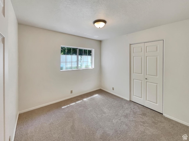 1227 Riverside Ave Unit 50, Provo, UT 84604 - unfurnished bedroom featuring a closet, light carpet, and a textured ceiling