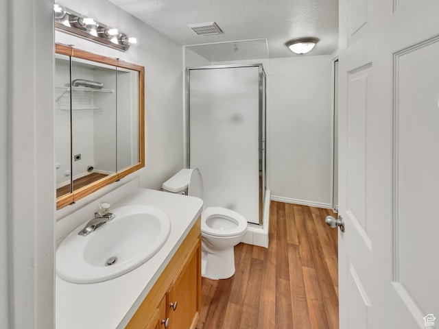 1227 Riverside Ave Unit 50, Provo, UT 84604 - bathroom featuring a shower with door, hardwood / wood-style flooring, a textured ceiling, and toilet
